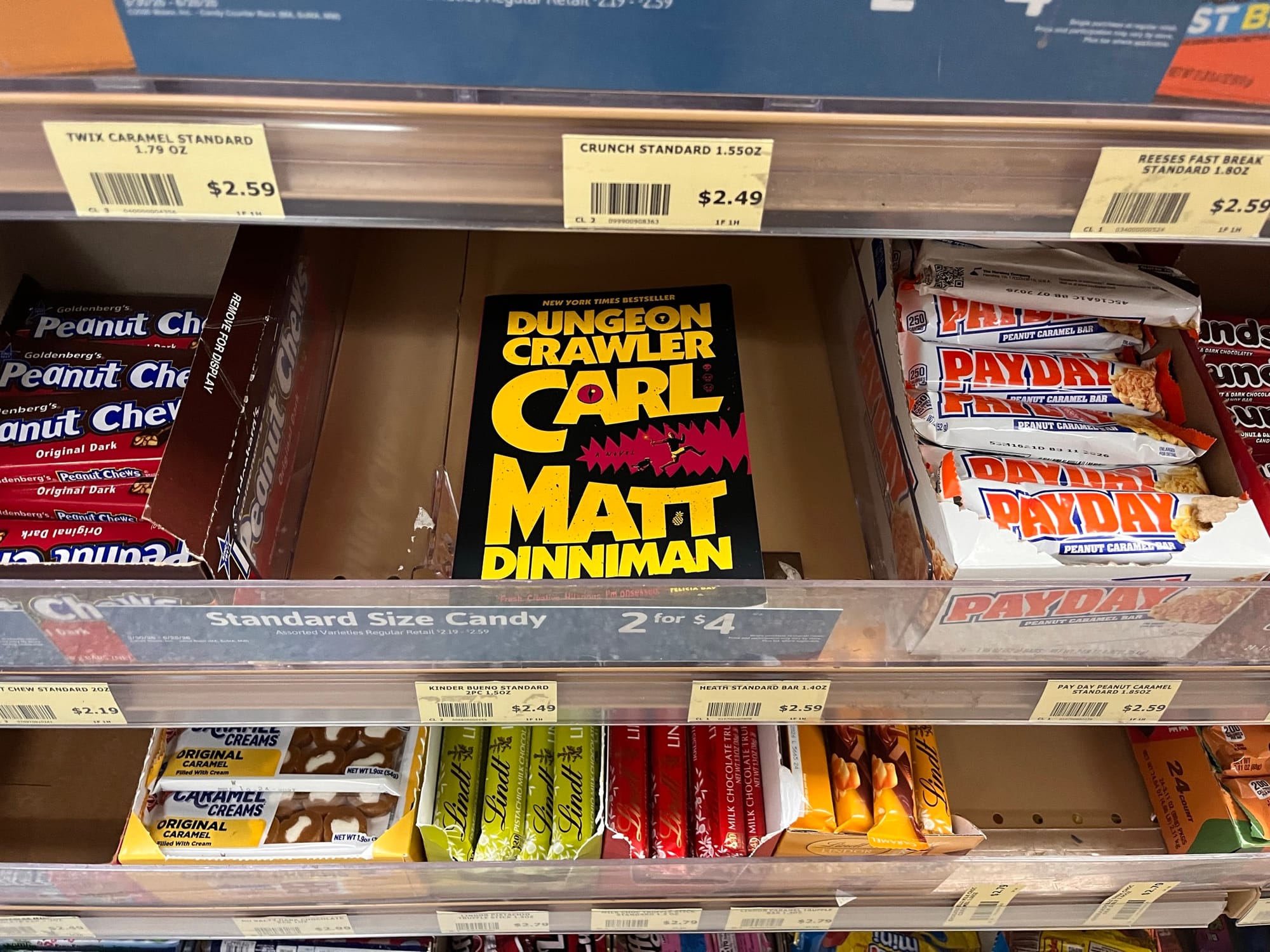 A copy of "Dungeon Crawler Carl," situated in the candy aisle at a grocery store.