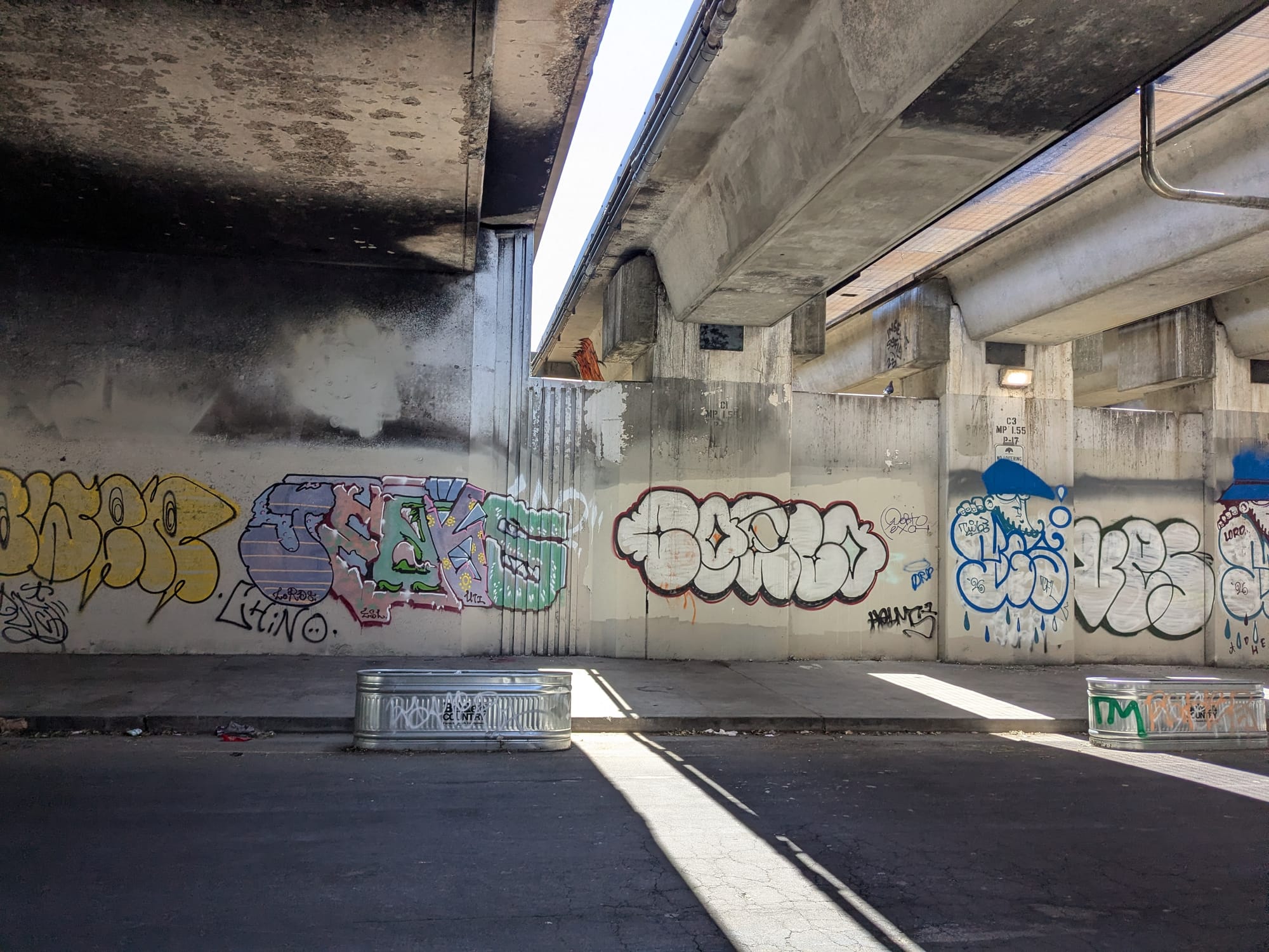a graffiti-filled street under an overpass