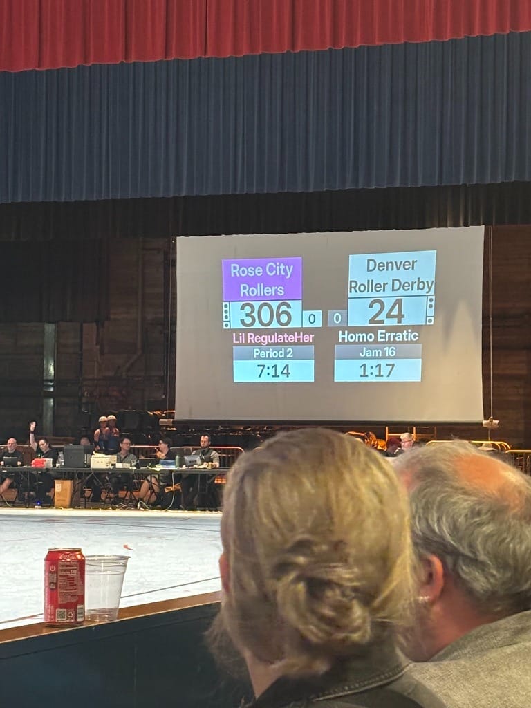 A photo of the scoreboard showing the Rose City Rollers leading the indifferently monikered Denver Roller Derby, 306–24. 