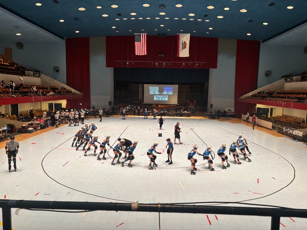 Skaters make their way around the rink, forming a half-circle a bit like a crooked smile.