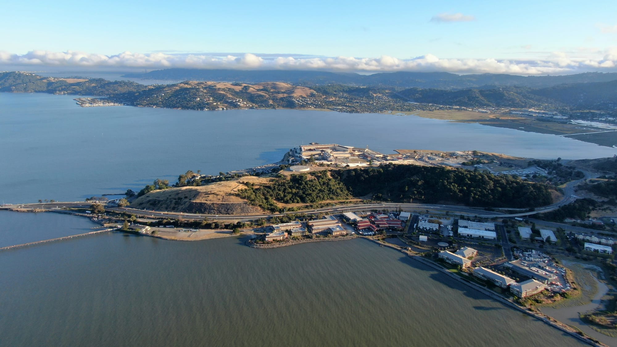San Quentin viewed from above, a collection of structures amid the green waters of the bay. 