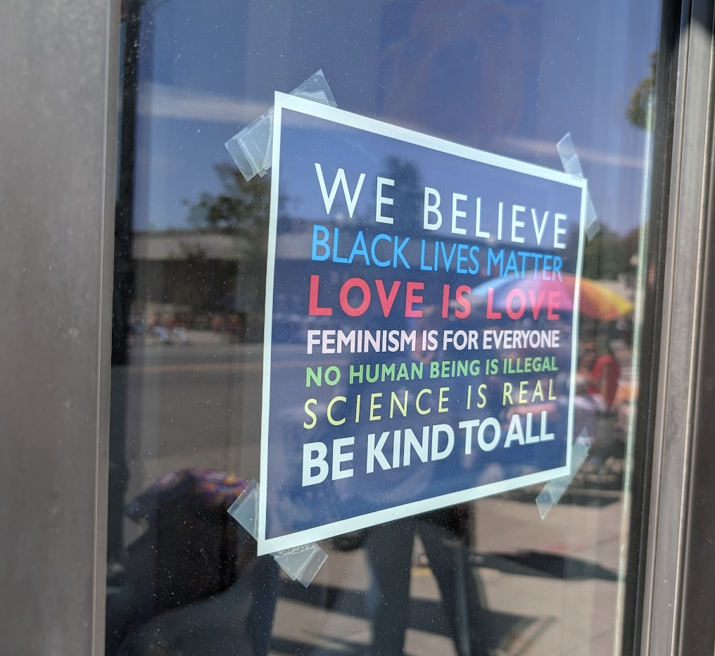 "we believe" sign reflecting fourth of july parade