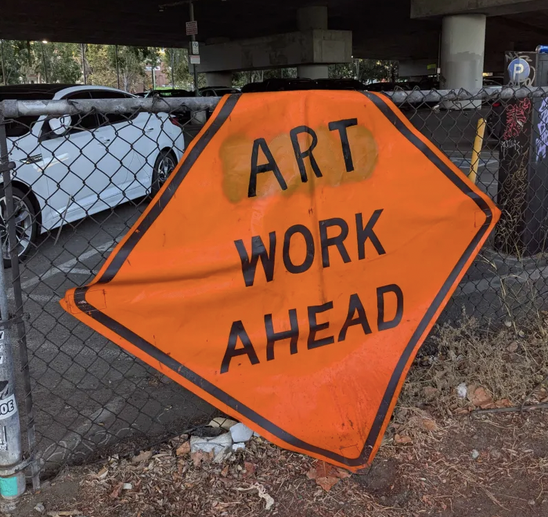 A street sign repurposed to say "Art Work Ahead"