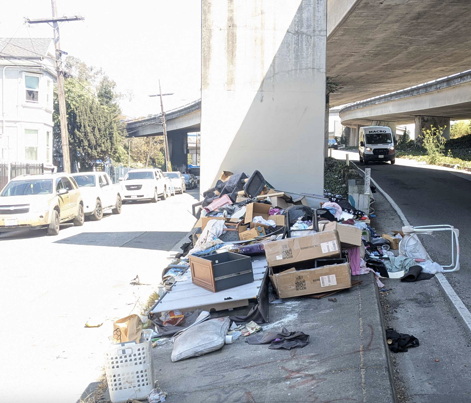 Trash in foreground on a street with a Macro van in the background.