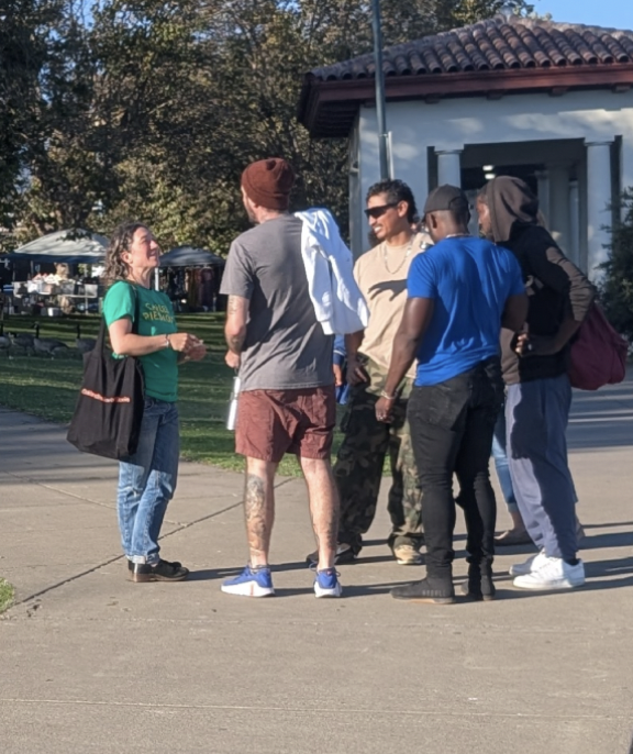 Woman in Cancel Piedmont shirt addressing a small group of lake walkers.