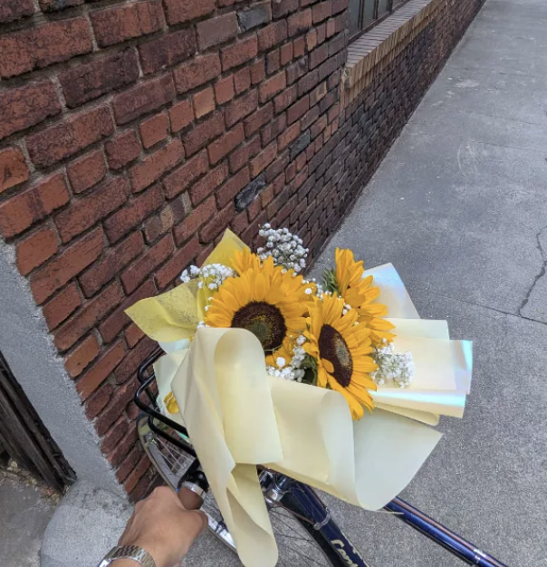 a bouquet of flowers held above a bike.