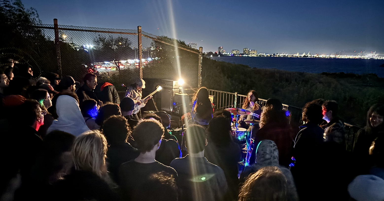 Band playing on the pedestrian bridge after sundown.