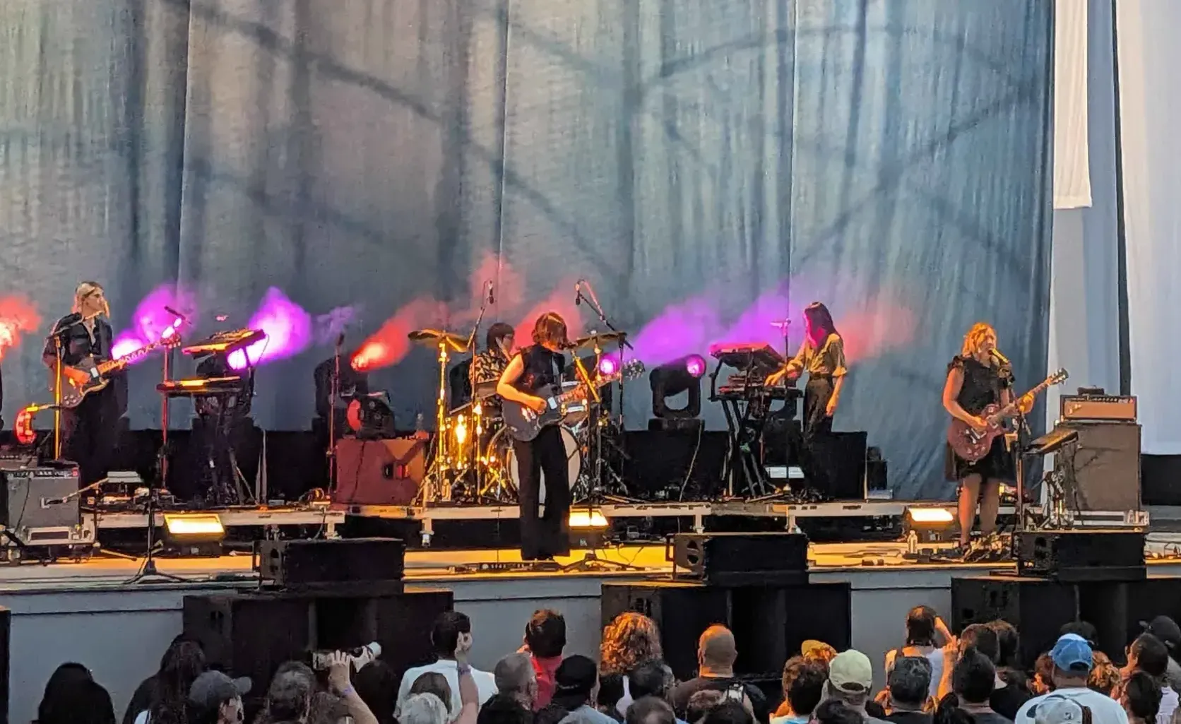 Sleater-Kinney on stage, with fans below (more dudes than expected tbh)