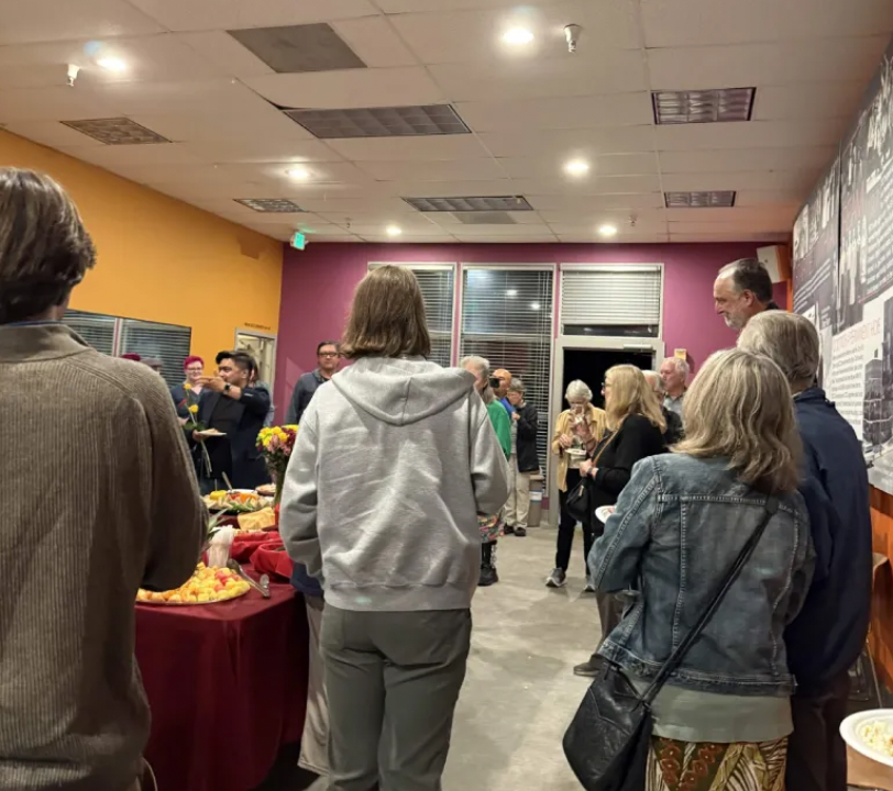 Theater-goers eating from an impossibly large charcuterie board.