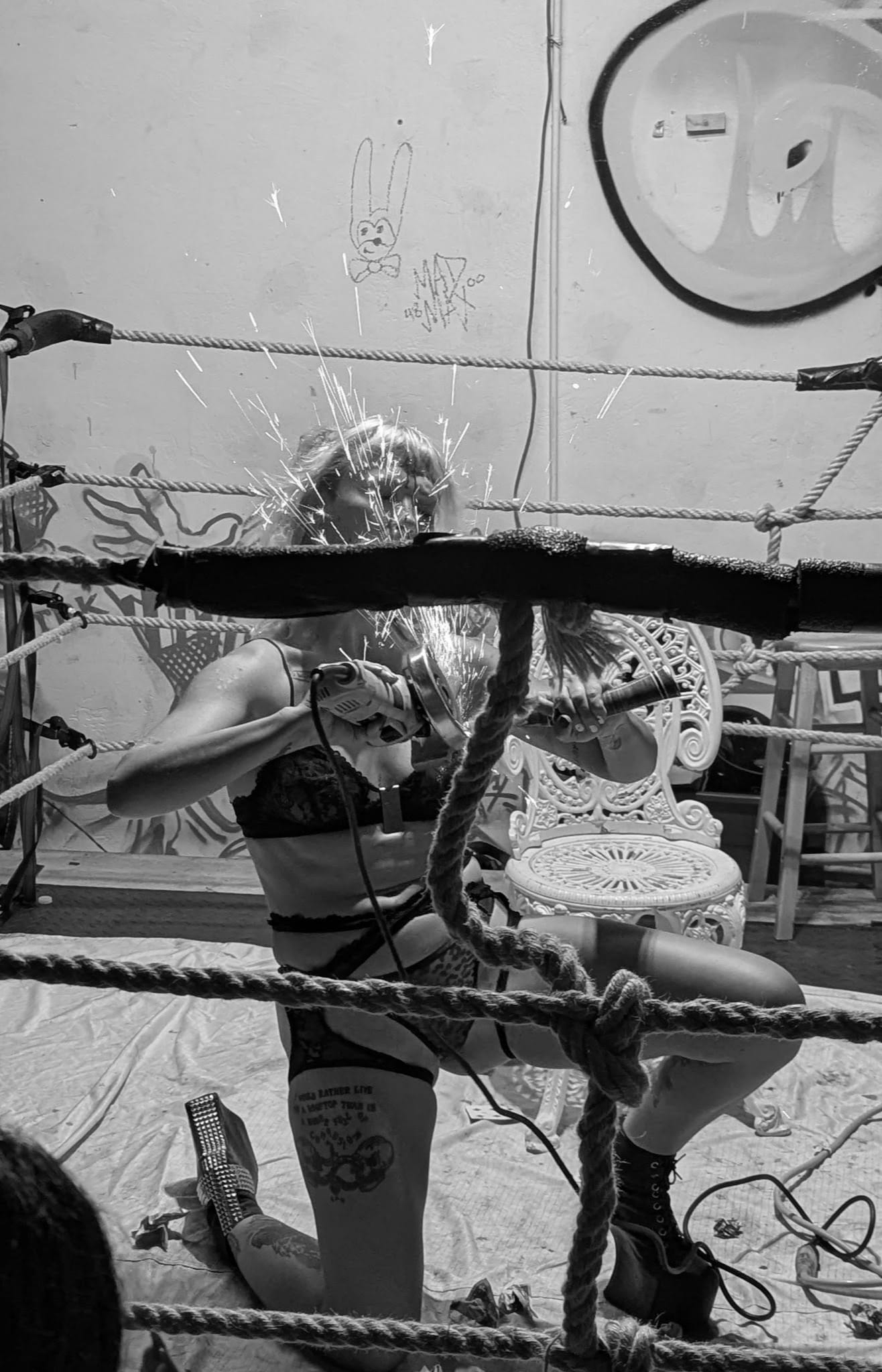 A woman with an angle grinder inside the ring.