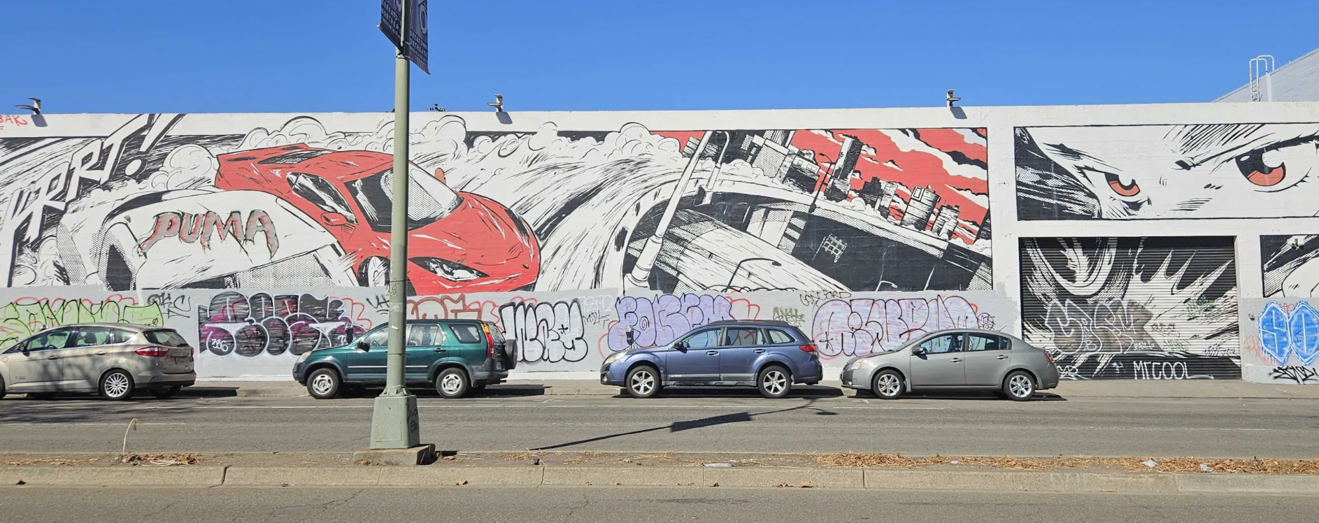 cars and street in front of murals of cars and streets.