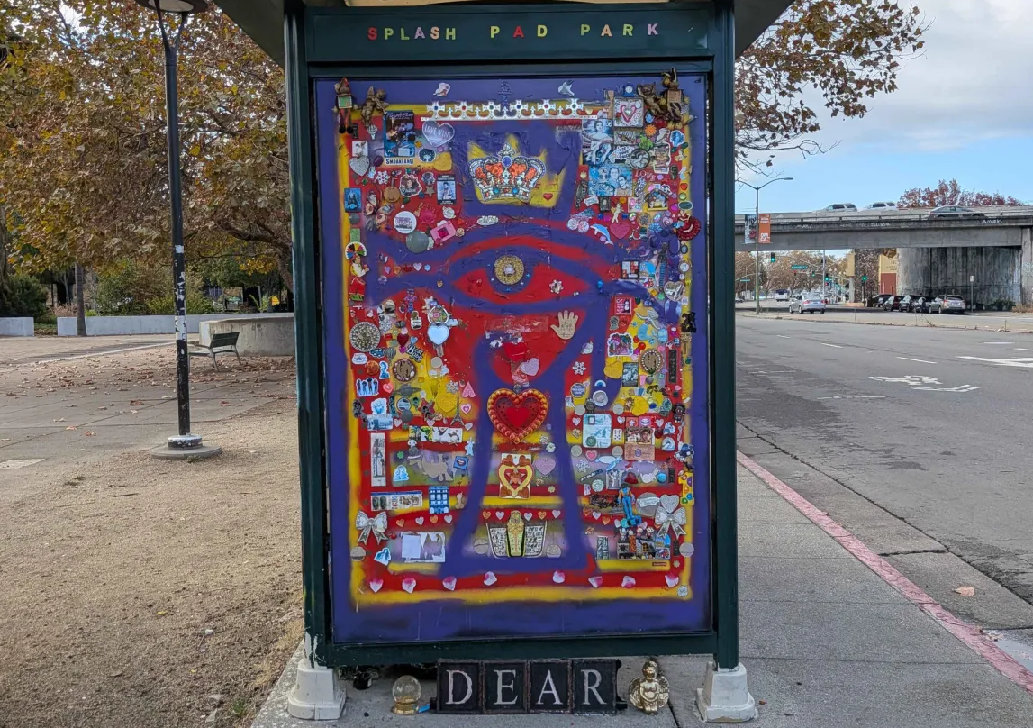 A window of the Splash Pad Park bus stop, colorfully decorated, with some text reading "DEAR" at the bottom.