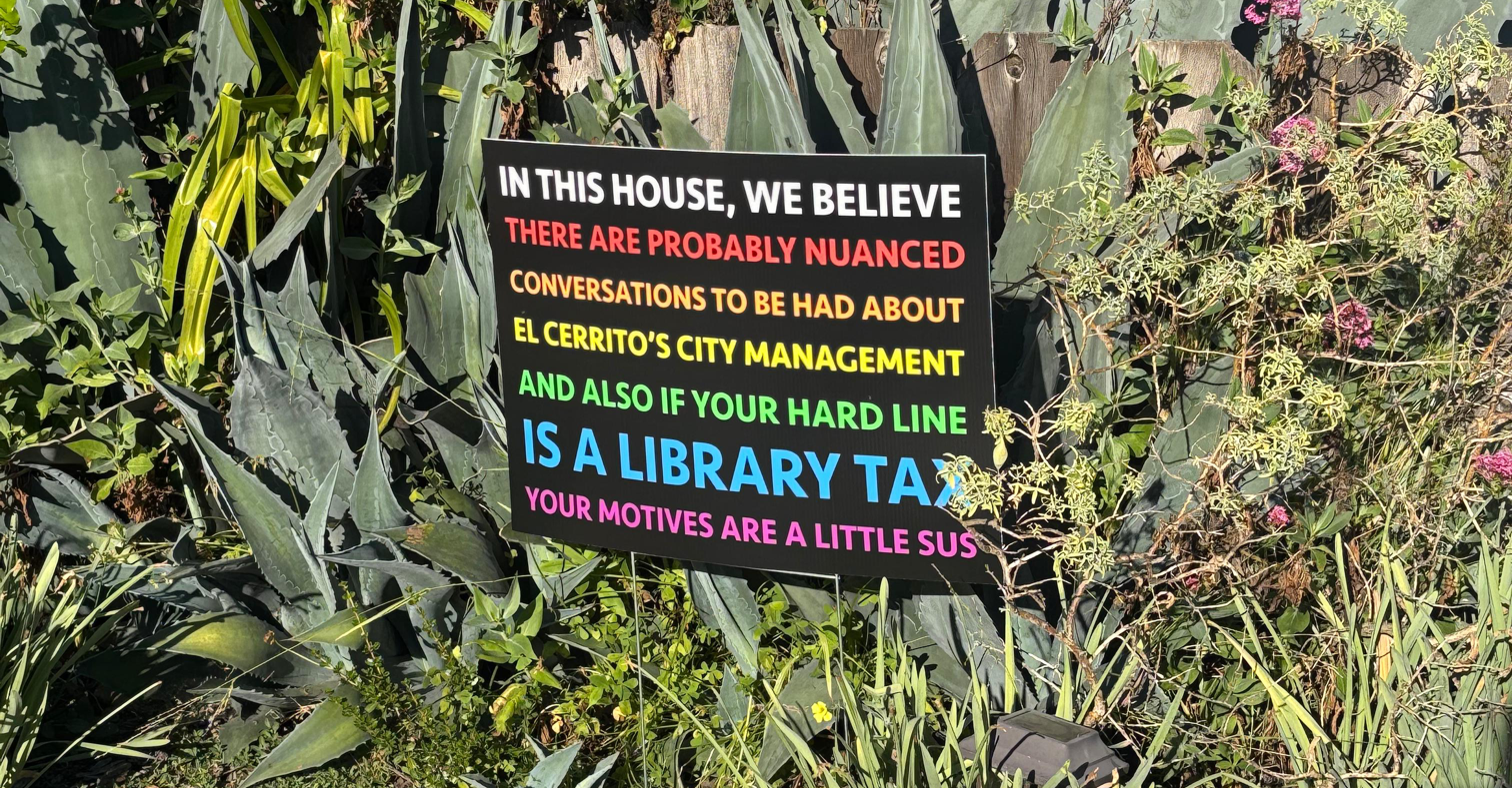 An "IN THIS HOUSE, WE BELIEVE" signs, archly rendered to question the opposition to a library tax. 