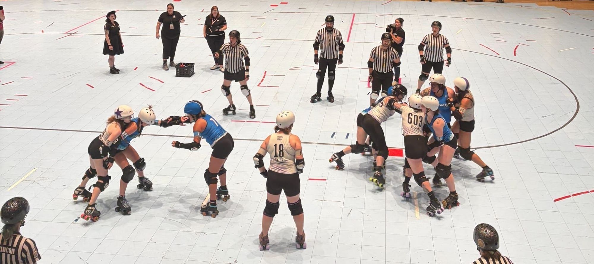 A chaotic scene from the action, with various players brawling and zebras looking on, and one player standing serenely in the middle of it all.