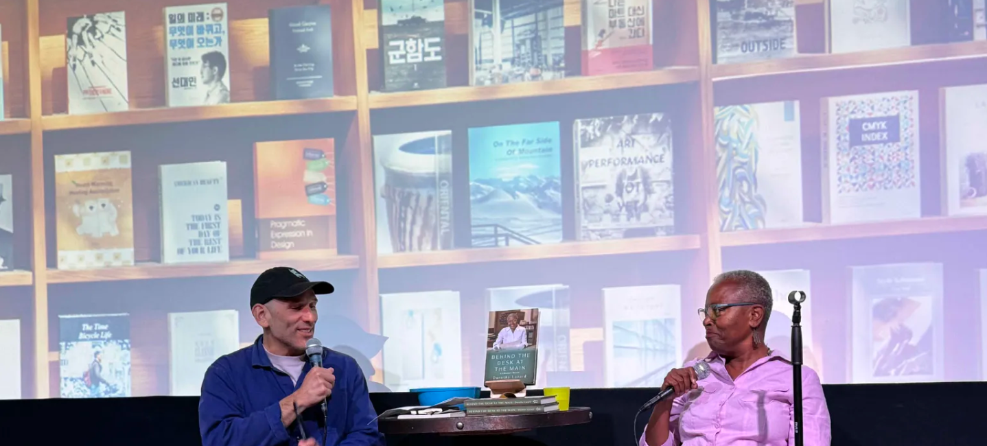 Alexis Madrigal and Dorothy Lazard meeting cute across a screened backdrop of books
