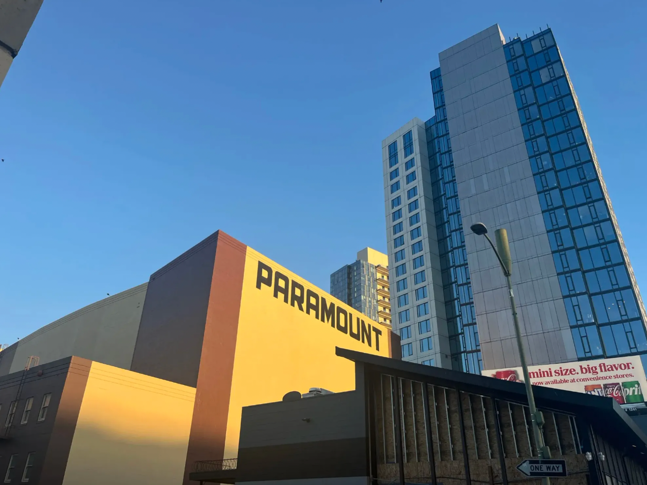 Photo of buildings, with one labeled "PARAMOUNT." A soda ad in the back reads "mini size. big flavor."