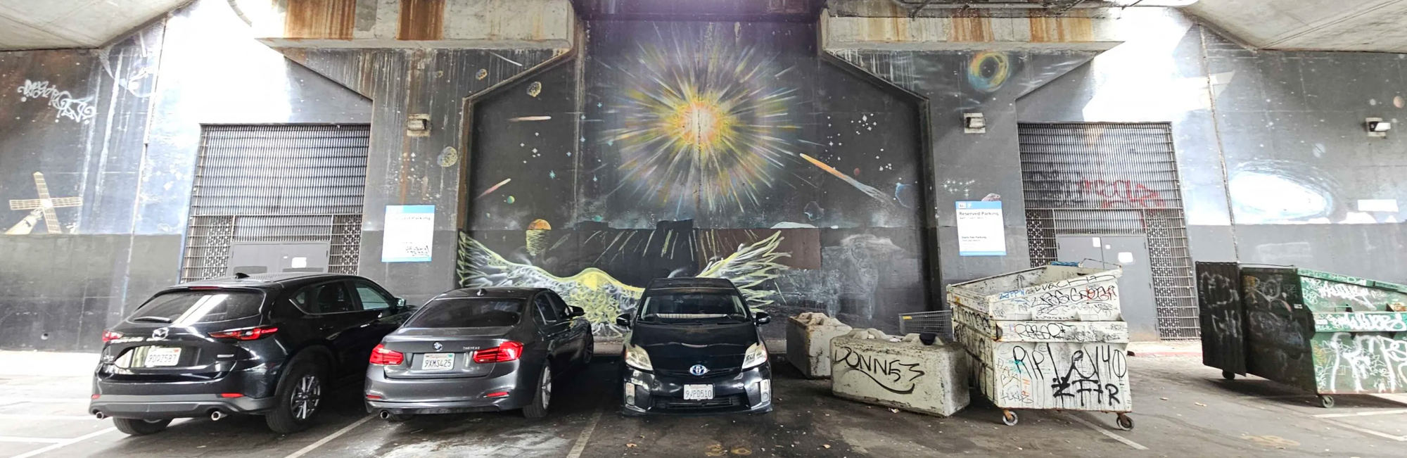 Some incredible planetary-themed murals with cars in the foreground.
