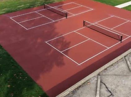 Two red pickleball courts with white lines and nets at Merriner Park in Streator