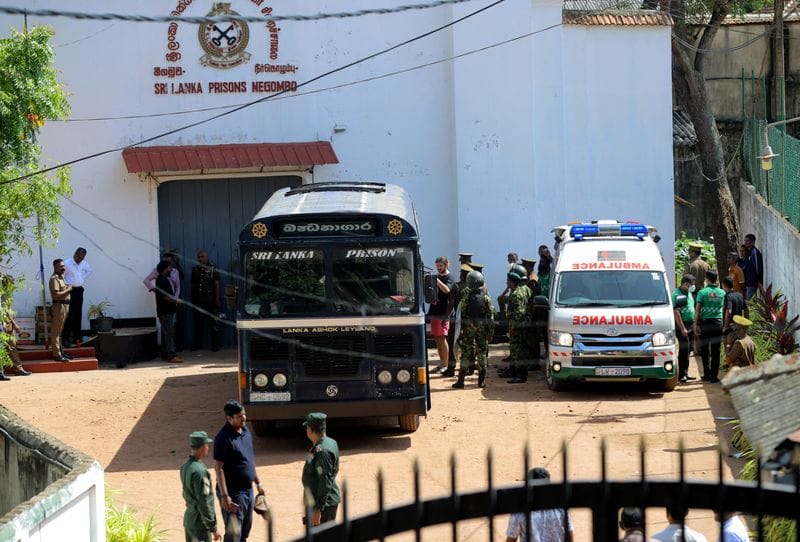 Prisoners board a bus to be transferred following clashes at Negombo Prison