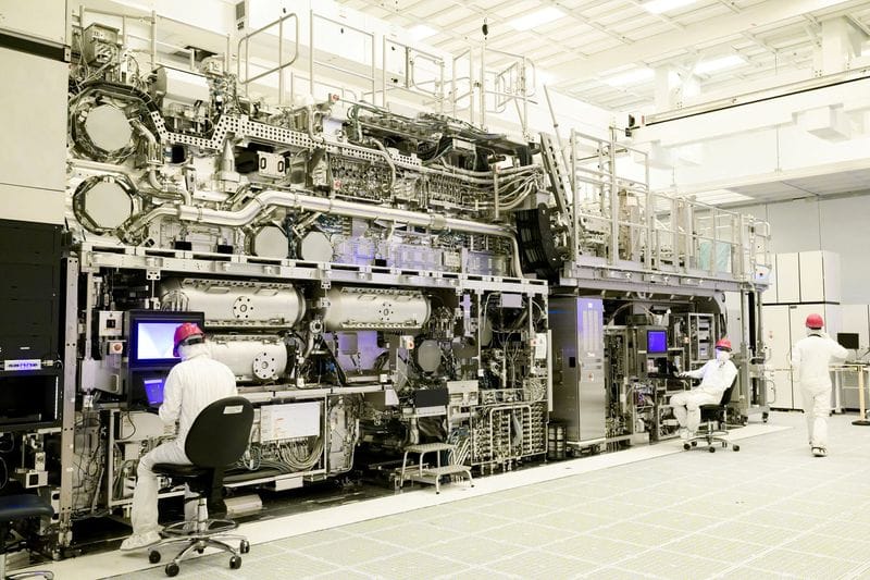 FILE PHOTO: Workers are seen in front of a "High NA EUV" lithography system at an Intel facility in Hillsboro
