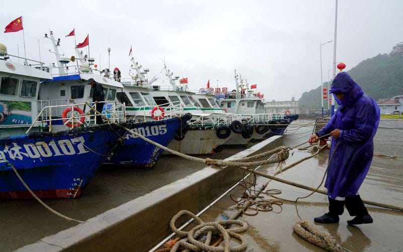 Crew member secures a boat at Nanyue Pier as Typhoon Dolphin approaches, in Yueqing Bay