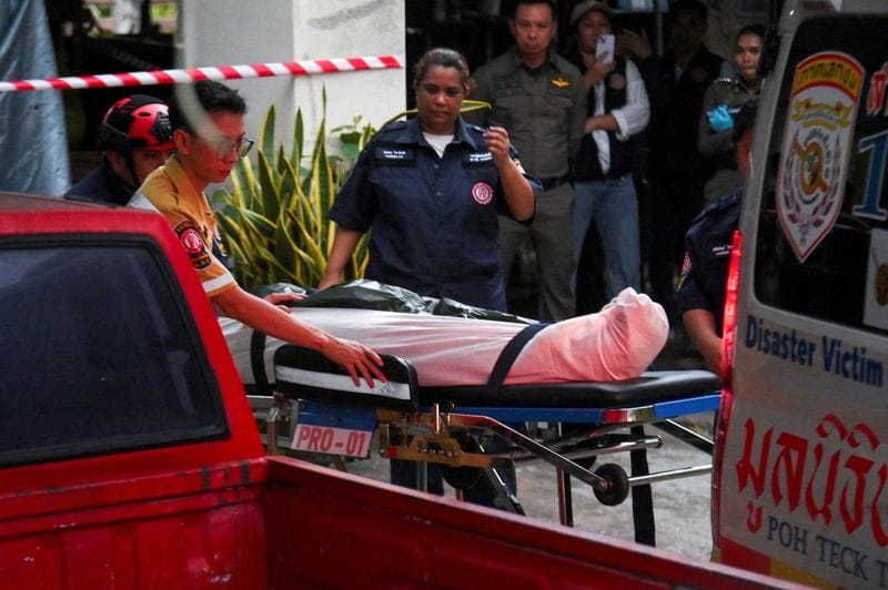 Emergency personnel carry the body of one of the grandparents fatally shot by a Thai teenager, before he opened fire at the Debsirin Nonthaburi School on the outskirts of Bangkok