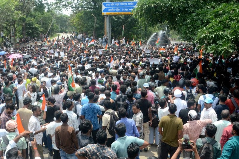 Demonstrators march on the state legislature as police use water cannons to disperse them during a protest, in Ranchi