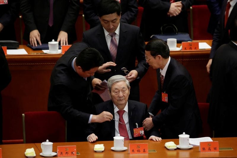 Former Chinese Premier Zhu Rongji (C) leaves after the opening of the 19th National Congress of the Communist Party of China at the Great Hall of the People in Beijing