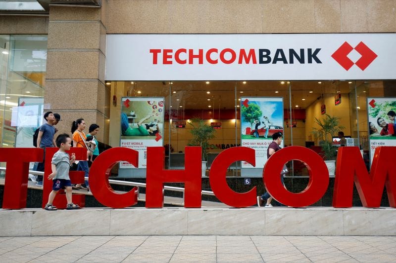 FILE PHOTO: People walk past the headquarters of Techcombank in Hanoi