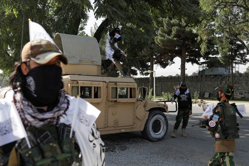 Taliban soldiers stand guard on the second anniversary of the fall of Kabul, on a street in Kabul