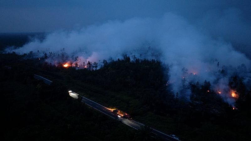 A drone view shows smoke rising from a wildfire burning in Tanjung Taruna village