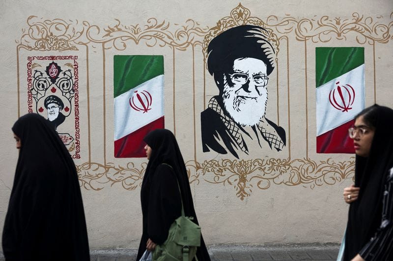 FILE PHOTO: People walk by a mural depicting Iran's late Supreme Leader Ayatollah Ali Khamenei in Tehran