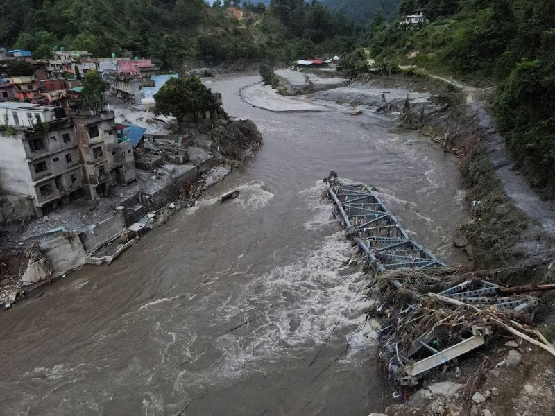 A drone view of a broken bridge and damaged houses after the flash floods and mudslide, at Devighat