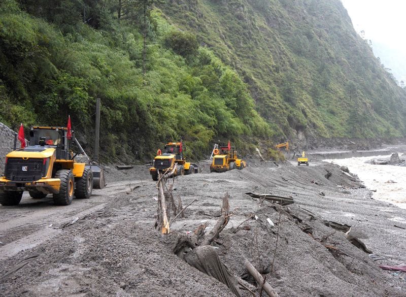 Rescue workers repair a road leading to Gyirong Port after a mudslide