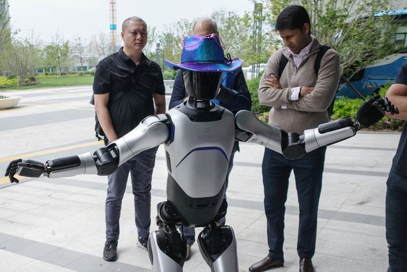 People interact with an Agibot RAISE A1 humanoid robot at the company's headquarters in Shanghai