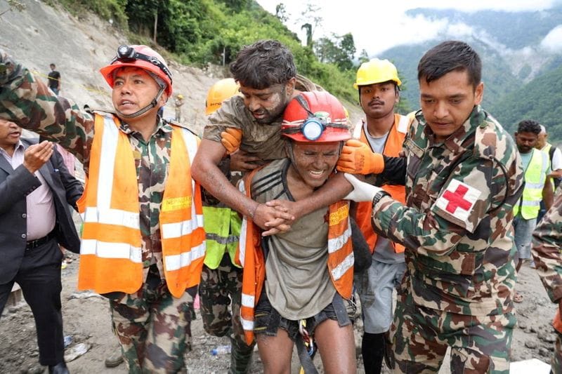 Sanjay Sah is carried by members of a search and rescue team after being rescued from inside a tunnel at the Trishuli-3A Hydropower Project following devastating floods and mudslides that