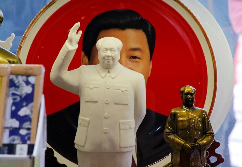 FILE PHOTO: Sculptures of the late Chinese Chairman Mao Zedong are placed in front of a souvenir plate featuring a portrait of Chinese President Xi Jinping at a shop in Beijing