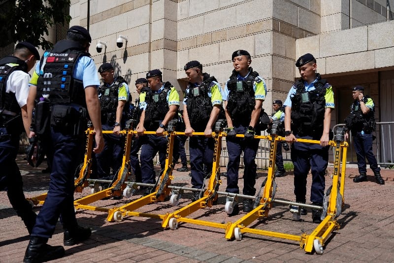 Police move a vehicle barrier outside West Kowloon Law Courts Building in Hong Kong