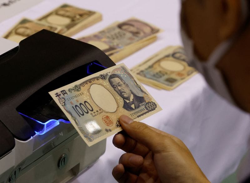 A worker holds a sample of a new Japanese yen banknote at a factory of the National Printing Bureau producing Bank of Japan notes at a media event about the new notes scheduled to be