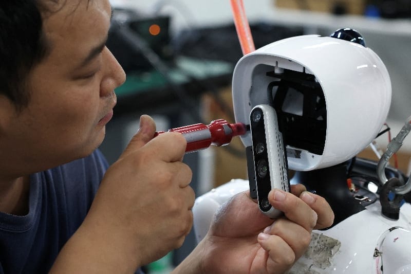 An engineer works on a Tiangong Omni humanoid robot in the research and testing area of the Beijing Humanoid Robot Innovation Center, also known as X-Humanoid, in Beijing, China, September 4, 2026. REUTERS/Tingshu Wang