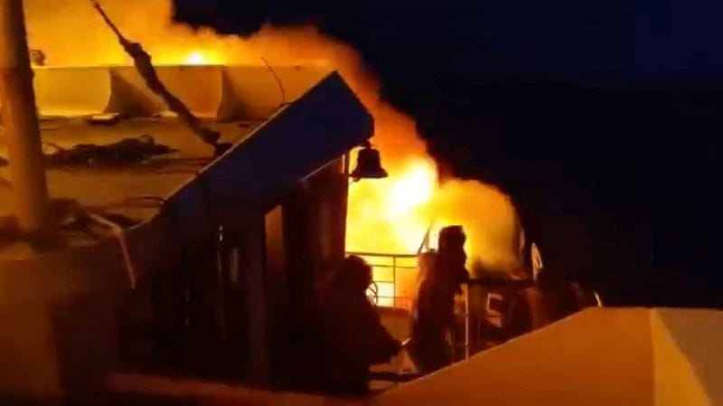 People stand aboard MV June Aster as flames and smoke rise after a fire broke out on the ferry, off the coast of Palawan, Philippines, in this screengrab taken from a handout video released on September 9, 2026. Philippine Coast Guard/Handout via REU
