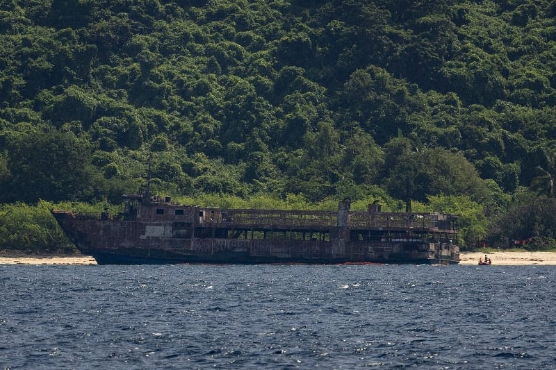 Members of the Philippine Coast Guard, in a dinghy, guard the burnt MV June Aster ferry that caught fire off the coast of Palawan, Philippines, September 13, 2026. REUTERS/Eloisa Lopez