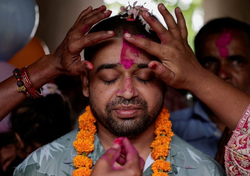 Family members offers tika to Sanjay Sah, a survivor pulled out alive after spending nine days trapped in a hydropower station tunnel following flash floods and a mudslide, upon his arrival at his house for the first time after being rescued from the