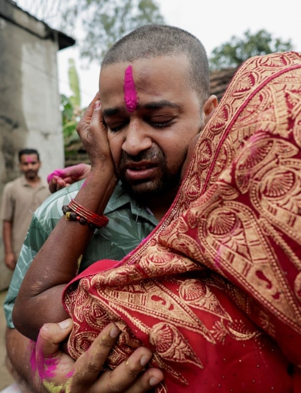 Kapur Devi Sah, mother of Sanjay Sah, a survivor pulled out alive after spending nine days trapped in a hydropower station tunnel following flash floods and a mudslide, gets emotional as she kisses her son upon his arrival at their house in Tilathi K