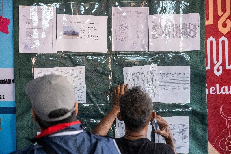 Relatives of passengers aboard the Virgo Transport 8 ship that, according to a search and rescue agency, sank while sailing from Surabaya in East Java to Banjarmasin in South Kalimantan, examine a manifest list as they look for news about the search