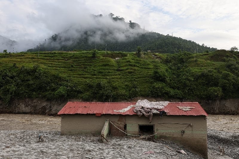 Mud partially buries a damaged house following deadly flash floods and a mudslide, in Dhading district, Nepal, September 14, 2026. REUTERS/Tyrone Siu