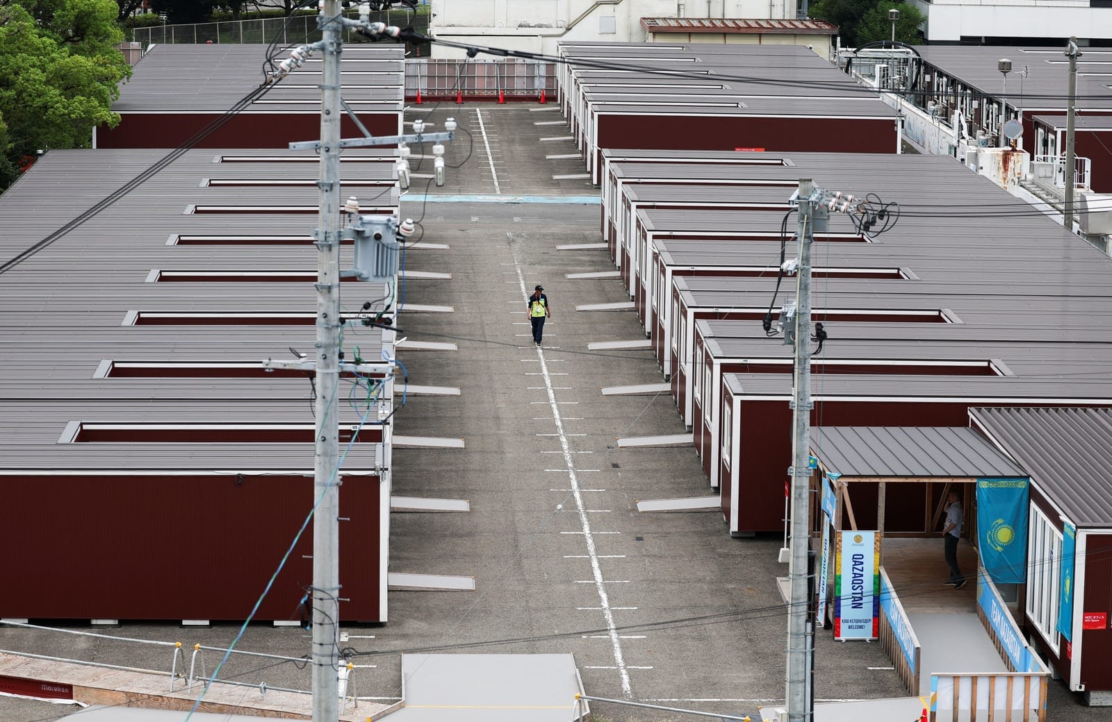 A person walks near wooden container units built to house athletes, ahead of the Aichi-Nagoya 2026 Asian Games, in Nagoya, Japan, September 15, 2026. REUTERS/Edgar Su