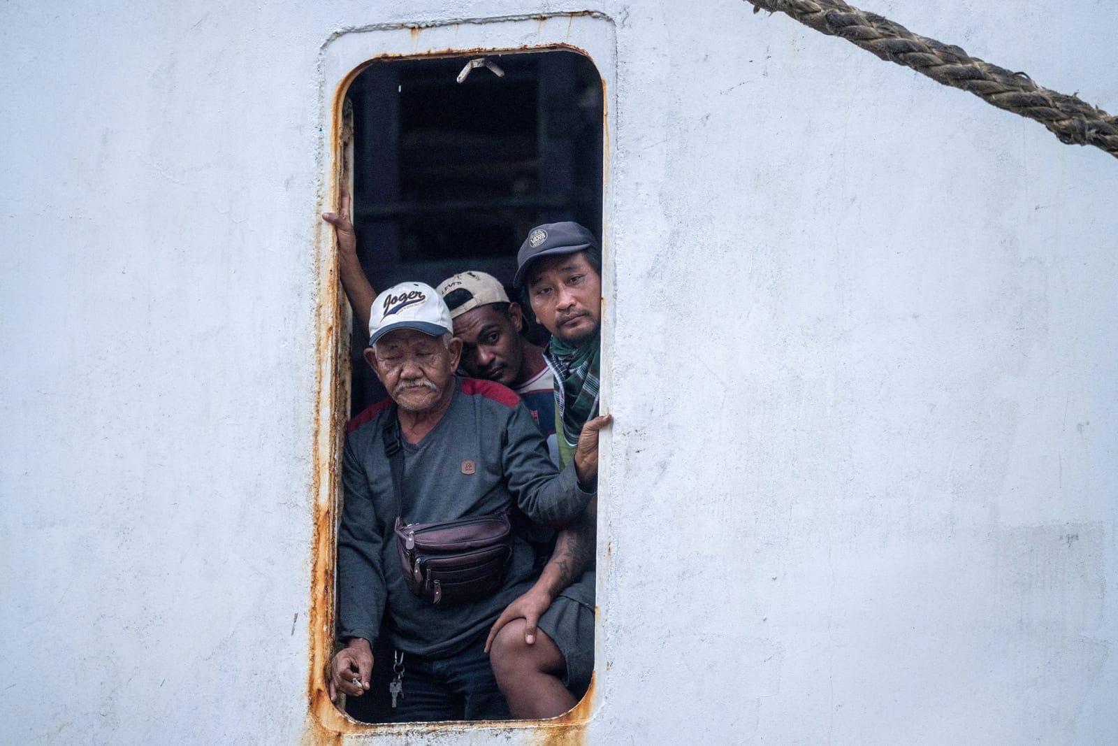 FILE PHOTO: Passengers evacuated from the Virgo Transport 8 ship that sank while sailing from Surabaya in East Java to Banjarmasin in South Kalimantan, look on as they arrive at Trisakti port in Banjarmasin, South Kalimantan province, Indonesia, Sept