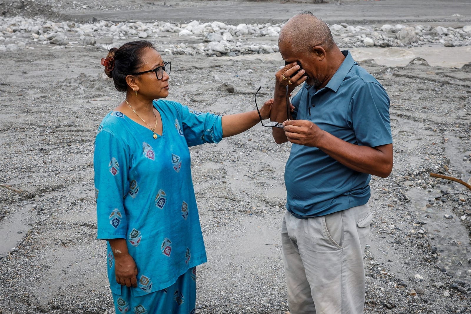 Chari Thapa Magar, 54, and Sita Thapa Magar, 45, who were displaced by recent flash floods and mudslides, cry as they pose for a photograph on the sludge that buried their home in Betrawati, Nuwakot district, Nepal, September 9, 2026. Sita Thapa Maga