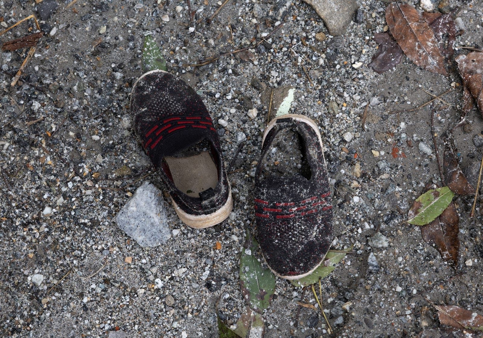 A pair of shoes belonging to a child, covered in sludge, lies on the grounds of Uttargaya Public School following flash floods and mudslides in Angitar, Nuwakot district, Nepal, September 6, 2026. There are 5,130 people still reported missing on the 